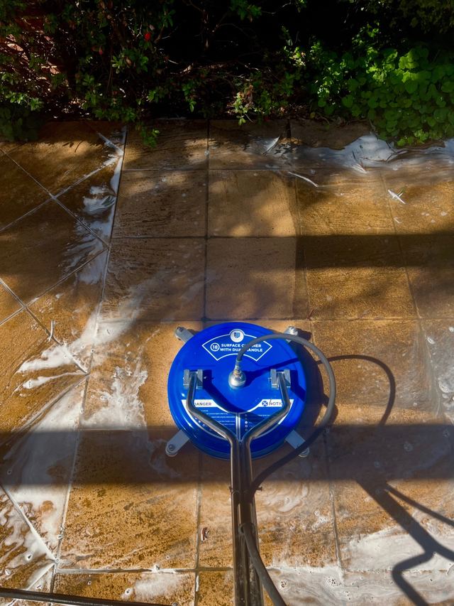Poli Clean team member pressure washing a driveway in Melbourne